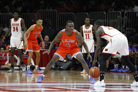 East St. Louis player defends as Bogan player dribbles.