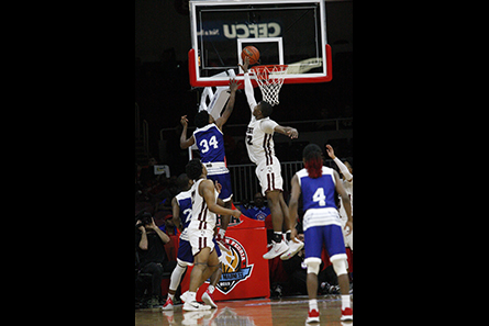 Two players mid-air at hoop. 