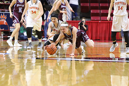 Toppers and Spartian players dive for a loose ball. 