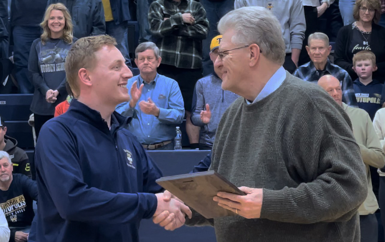 Steve Raymond shakes hand with Teutopolis High School Derrick Zerrusen